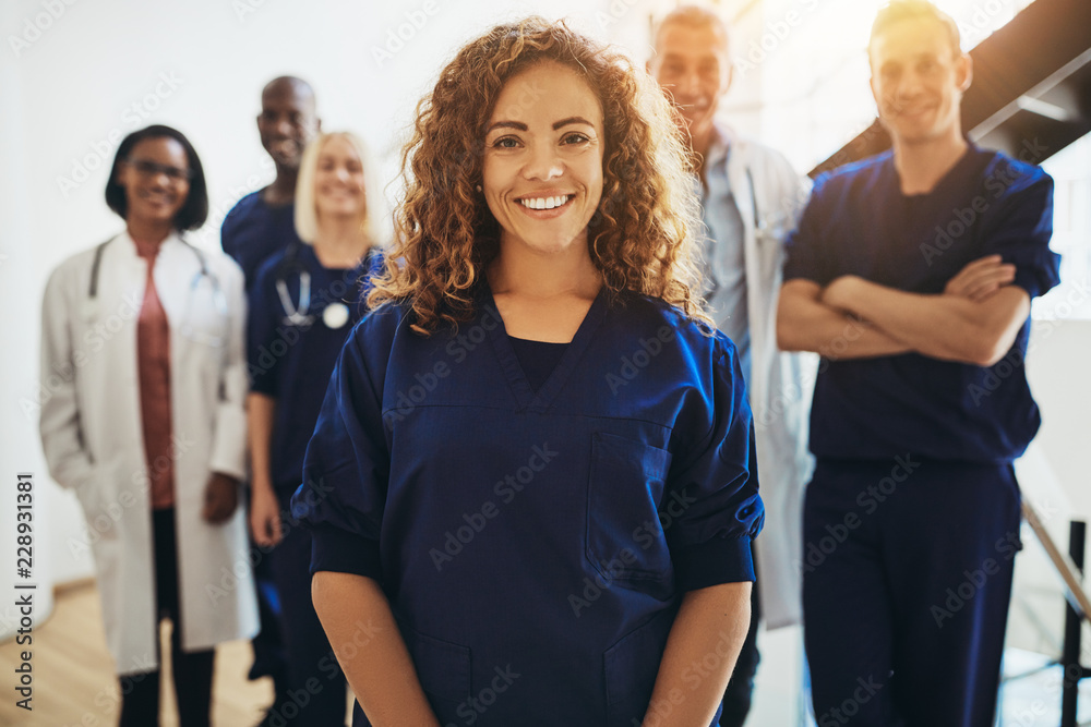 Smiling female doctor standing with medical colleagues in a hosp